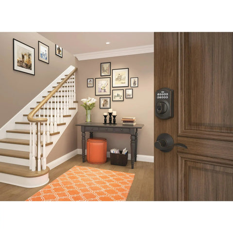 Camelot Keyless Entry Electronic Keypad Deadbolt Lock With Aged Bronze Finish installed on a wooden front door in a hallway.