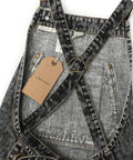 Close-up of black denim apron with cross back straps and deep pockets for hair stylists, baristas, gardeners, and craft pros.