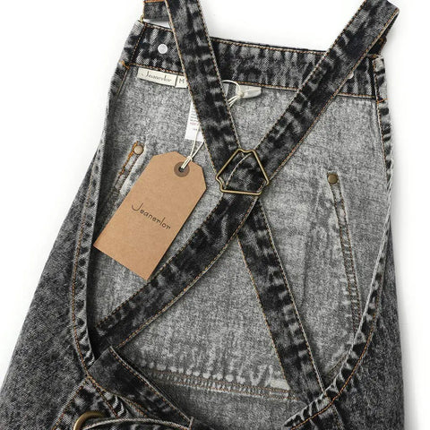 Close-up of black denim apron with cross back straps and deep pockets for hair stylists, baristas, gardeners, and craft pros.