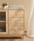 Four Piece Flower Shape Cabinet Knob Set In Rose Gold With Crystal Glass Pull Handles installed on wooden cabinet drawers.