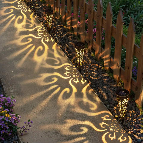 Solar Powered Fire Totem Style Outdoor Garden Lights Six Pack Waterproof Conical Stakes illuminating a garden pathway