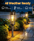 4 Pack Solar Firefly Lights Outdoor Garden Decor With 32 LED Swaying Iron Wire Bulbs illuminating a rainy backyard pathway