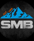 SMB logo with blue mountain design and 'EST. 1999' inscription on a circular black background