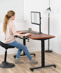 Woman using two pack clamp adjustable armrests at a desk with a computer for ergonomic support in a home office.