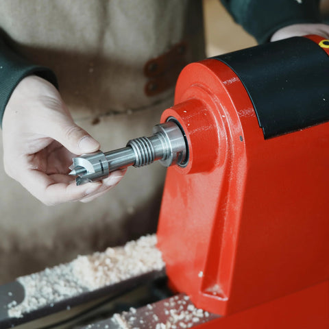 BMWOOD 4-prong spur drive center with 2MT shank and 1-inch diameter, held by hand beside a red wood lathe.