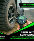 Close-up of Rhino USA digital tire pressure gauge with inflator, 2-inch dial and stainless braided hose connected to a vehicle tire.