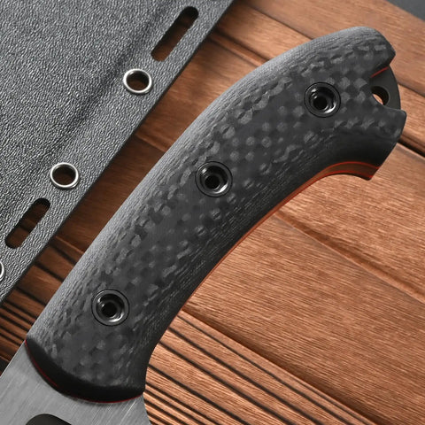 Close-up of carbon fiber handle on Rugged Fixed Blade Knife With DC53 DLC Coated Nine Point Eight Four Inch Blade Carbon Fiber Handle Full Tang Build Includes Sheath Built For Outdoor Camping Hunting And Tough As Nails Work Premium Steel Edge For Heavy Use against a wood background.