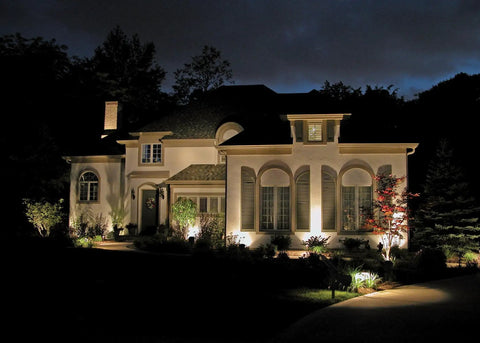 Sun Powered 4 LED Solar Spotlight Kit illuminating house facade at night, 2 Pack, 2 In 1 Adjustable Wall And Landscape Lights shown
