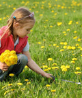 Child using 11.5 Inch Dandelion Weeder Puller Tool With Soft Grip Handle Stainless Steel Two Pronged Weeding Fork in field.