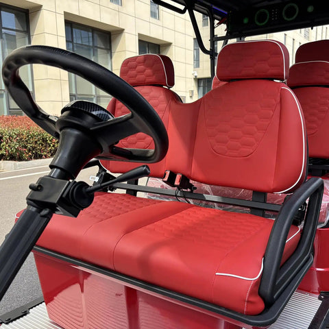 Heavy Duty Six Passenger Electric Golf Cart With Six Point Three Kilowatt AC Motor And Forty Eight Volt Electronics Built In Solar Panels Remote Key Fob And Dope Candy Apple Red Paint For No Sweat Fairway Cruising interior showing red seating and steering wheel.