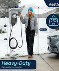 Outdoor EV Charger Pedestal Stand for Tesla and J1772 Type 2 Chargers shown installed on snowy driveway with woman and car.