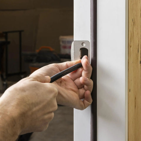 Using Heavy Duty No Sweat Self Centering Screw Hole Punch With Hammerless Spring Action on wooden door frame for precise drill marks.