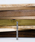 SpeTool spiral router bit, down-cut, 1/4 in dia, 1/4 in shank, solid carbide, standing in front of stacked wood boards
