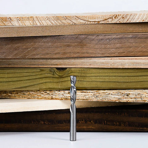 SpeTool spiral router bit, down-cut, 1/4 in dia, 1/4 in shank, solid carbide, standing in front of stacked wood boards