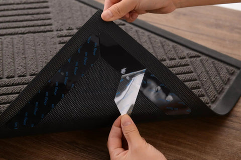 Peeling adhesive backing of Non Slip Rug Pads 12 Pack Gripper For Hardwood Floors Tile And Wood Under Rugs