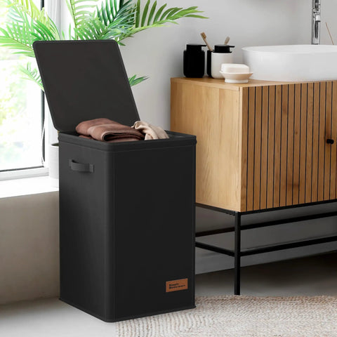 Black foldable laundry hamper with lid open, revealing clothes inside. Durable polypropylene tote for dirty clothes storage.