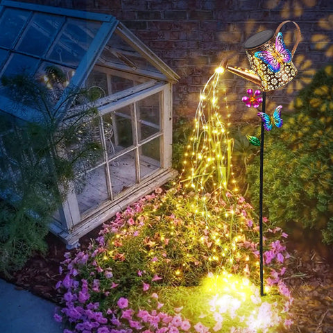 41 Inch Tall Solar Watering Can With LED Lights Garden Stake featuring butterfly and flower accents illuminating a garden path
