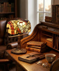 Stained Glass Butterfly Style Bankers Lamp With Handcrafted Design on wooden desk in cozy reading nook