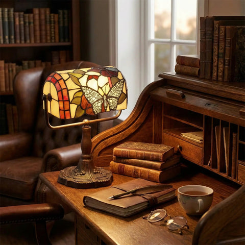 Stained Glass Butterfly Style Bankers Lamp With Handcrafted Design on wooden desk in cozy reading nook