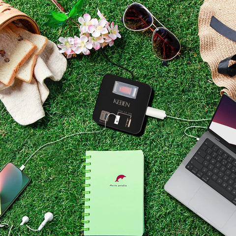 Travel Friendly Power Strip Cube With USB C 5ft Extension Cord Compact Weatherproof Surge Protector on grass with devices