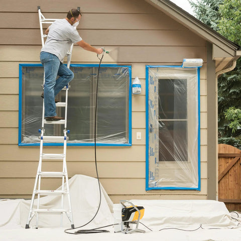 Professional HEA Airless Paint Sprayer in use on exterior house, person on ladder applying paint to wall, protective covering in place.