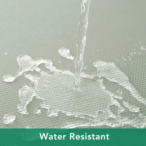 Close-up of water being poured on a 54x54 Inch Sage Square Tablecloth, Linen Like, Water Resistant And Washable, showing water resistance.