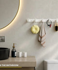 Heavy Duty Wall Mount Coat Rack Featuring Five Lock Down Hooks For All Your Everyday Essentials Like Hats Keys Wallets And Bath Towels Crafted From Corrosion Proof Aluminum In Crisp White Two Pack Bundle, displayed in a bathroom.