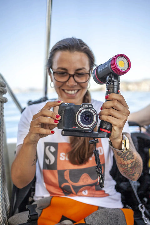 Person holding camera with Underwater Photo And Video Light Beast 2500 Lumen COB LED, demonstrating wide beam capability outdoors