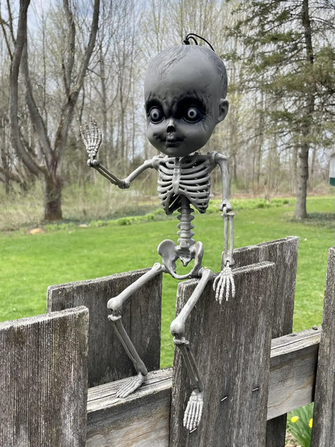 18 Inch Creepy Skeleton Boy Doll With Movable Joints sitting on a fence, Durable All Weather Plastic, Perfect Halloween Display Prop