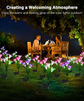 Six Pack Solar Garden Lights With Lily Flowers illuminating a patio at night, featuring color-changing LEDs in a garden setting.