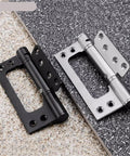 Two Hidden Stainless Steel Door Hinges With Hydraulic Buffer Damping Slick Spring Loaded Cabinet Door Closer Rust Resistant Furniture Hardware 5 Inch Easy Install For Smooth Soft Close Doors And Cabinets, one black and one silver, displayed on stone tiles.