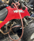 One Half Inch X Eight Foot Self Priming Jiggler Siphon Hose Transfers Gas Water Oil Fast Up To Four Gallons Per Minute on a red ATV engine.