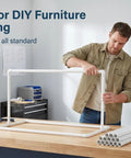 Man assembling frame with 12 Pack Half Inch PVC Pipe Sch 40 Furniture Grade White Plastic Pipe 17 Inch Length For DIY Projects Home Garden Greenhouse Farm Workshop Industrial Strength Crack Resistant And Straight