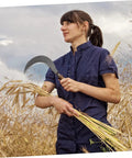 Person holding a sickle in a field, demonstrating use of Replacement Sickle Heads 9 Pack Carbon Steel Weeding Blades No Handle For Lawn Care.