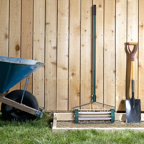 Rolling Lawn Aerator 18 Inch Rotary Push Tine Spike Soil Aerator with 3 Piece Long Steel Handle against wooden fence