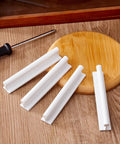 White Four Pack Self Adhesive Edge Finger Pull Door Handles on wooden surface with screwdriver next to circular board.