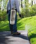 Person using 3 Gallon Stainless Steel Hand Pump Sprayer With Pressure Gauge, Adjustable Brass Nozzle for lawn care.