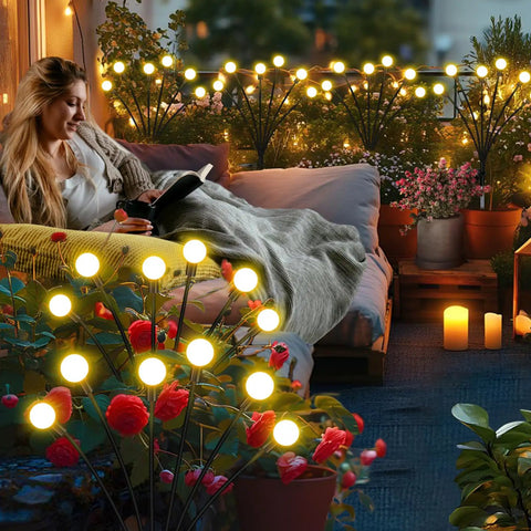 Woman relaxes with Solar Garden Lights Outdoor 4 Pack Firefly Swaying Lights Waterproof Garden Decor illuminating cozy patio.