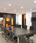 Modern conference room with 4 Inch LED Gimbal Recessed Downlight 500 Lumen, 90 CRI, 3000K, Matte White lighting installed.