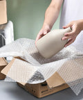 Person packing a vase with Bubble Cushioning Wrap Roll 12 Inch Wide, 72 Feet Total, Two Perforated Rolls With Easy Tear, Includes 20 Fragile Labels