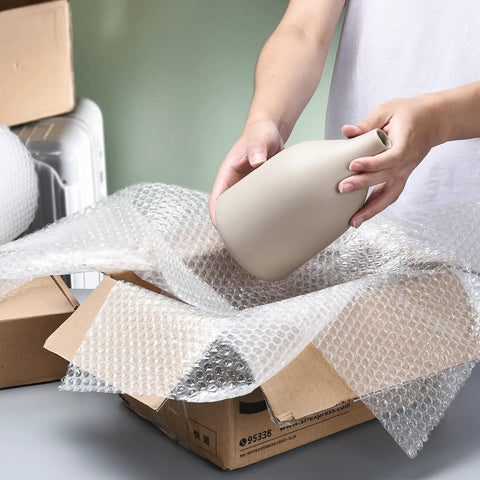 Person packing a vase with Bubble Cushioning Wrap Roll 12 Inch Wide, 72 Feet Total, Two Perforated Rolls With Easy Tear, Includes 20 Fragile Labels