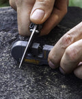 User sharpening a knife with the Dual Stage Knife Sharpener With Preset Carbide And Ceramic Slots Plus Retractable Diamond Rod.
