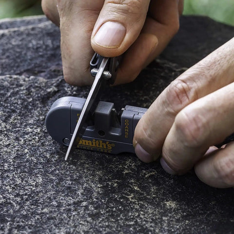 User sharpening a knife with the Dual Stage Knife Sharpener With Preset Carbide And Ceramic Slots Plus Retractable Diamond Rod.
