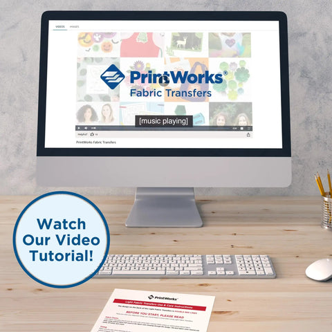 Computer screen with PrintWorks Fabric Transfers video tutorial, keyboard and paper, watch our video tutorial sign, desktop setting.