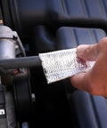 Person installing aluminized heat sheath sleeving with half inch inner diameter three feet long on engine hose
