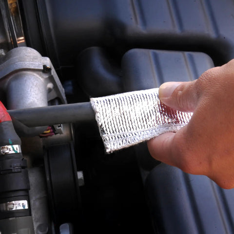 Person installing aluminized heat sheath sleeving with half inch inner diameter three feet long on engine hose