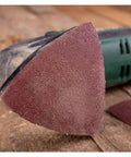 Close-up of triangular hook loop sanding disc for wood carving and multi-tool use with aluminum oxide grit.