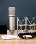 Ma-87 Studio Condenser Microphone with 26mm Gold Diaphragm Capsule for Singing, Vocal Recording, and Podcasting on desk with accessories.