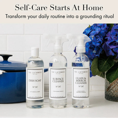 Go-To All Purpose Surface Cleaner No 247 Scent bottle next to dish soap and glass cleaner, on countertop with blue flowers