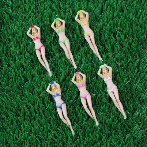 Six plastic figurines in colorful bikinis on grass, not related to Six Color 3 Inch Plastic Golf Tees Set Novelty Practice Tees.